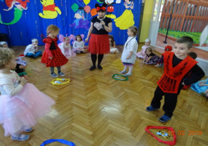 Nauczycielka przebrana za Myszkę Miki oraz czworo dzieci stoi przy szarfach.